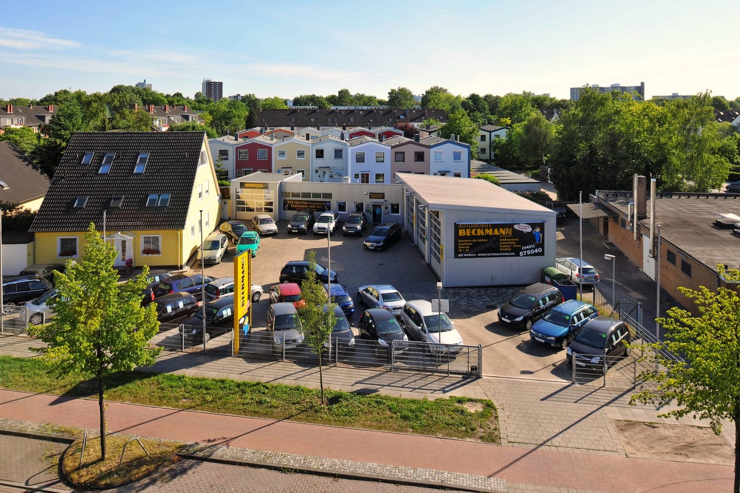 Das Gelaende von Automobile Beckmann am Arsterdamm 85 von oben: Einfahrt, Hof mit Stellplaetzen, die beiden Werkstatthallen und das gelbe Wohnhaus